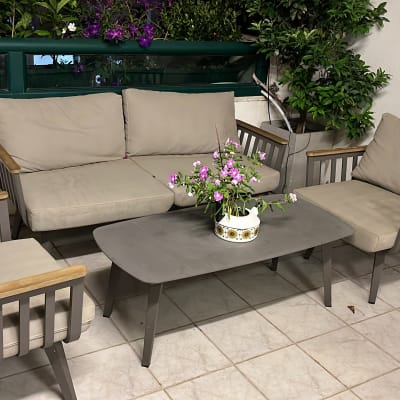 ריהוט גן עם כריות ישיבה ושולחן במרפסת