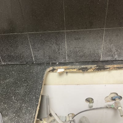 חיתוך והתאמת משטח שיש שחור במטבח לקראת התקנת כיור