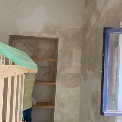 קיר מטויח עם מדפים פתוחים וחלון פתוח