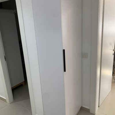 ארון לבן עם ידית שחורה במסדרון