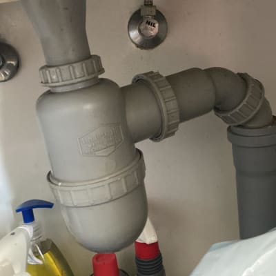 צנרת מתחת לכיור עם מוצרי ניקוי