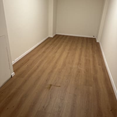 חדר עם רצפת פרקט עץ בהירה וקירות לבנים