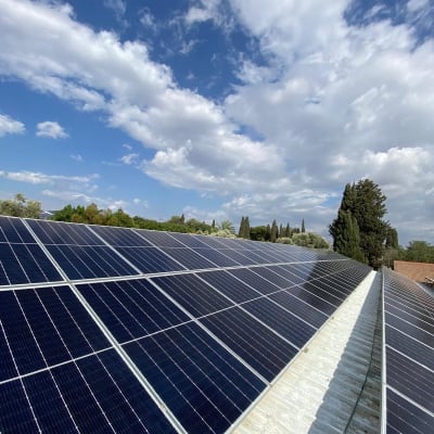 פאנלים סולאריים מותקנים על גג תחת שמיים כחולים