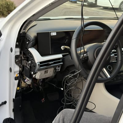 פנים רכב עם לוח מחוונים מפורק וחוטים חשופים
