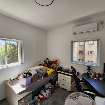 חלונות אלומיניום בחדר עם שולחן ומיטה