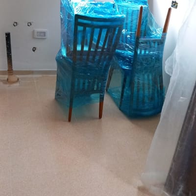 כיסאות עטופים בניילון כחול בחדר ריק