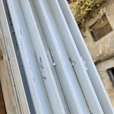 תריסים לבנים עם סימני שחיקה וחלודה