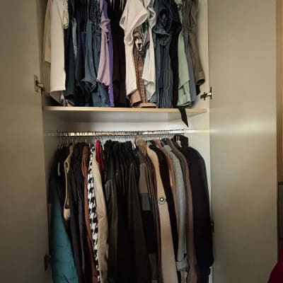 ארון בגדים מאורגן עם בגדים תלויים ומקופלים