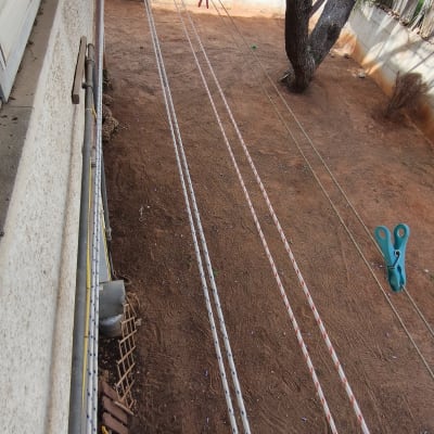חבלים לתליית כביסה בחצר עם אטב פלסטיק ירוק