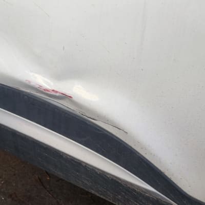 שקע ושריטות על דלת רכב לבנה