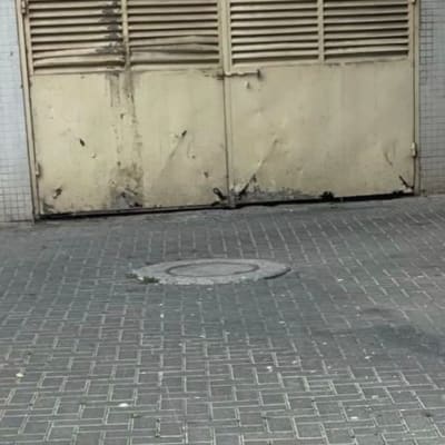 דלת מתכת ישנה עם תריסים, על רקע קיר לבנים