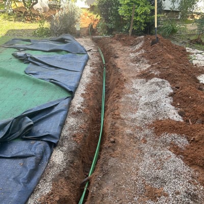 תעלה באדמה עם כבל ירוק מונח בתוכה