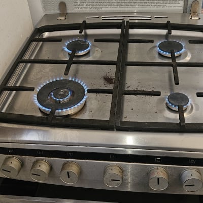 כיריים גז עם להבות כחולות וכלי עבודה צהובים
