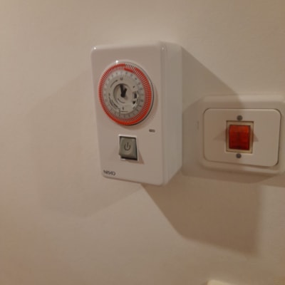 שעון טיימר חשמלי על קיר עם מתג