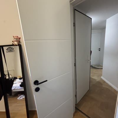 דלת לבנה עם ידית שחורה פתוחה למחצה