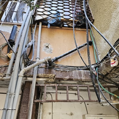צינורות מים וחוטי חשמל מחוברים לקיר חיצוני