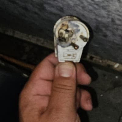 יד מחזיקה תקע חשמלי ישן עם סימני שחיקה