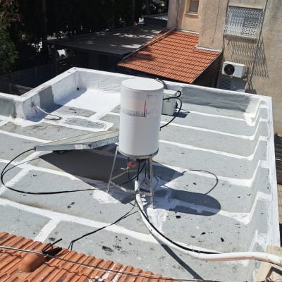 גג אטום עם חומר לבן סביב דוד שמש