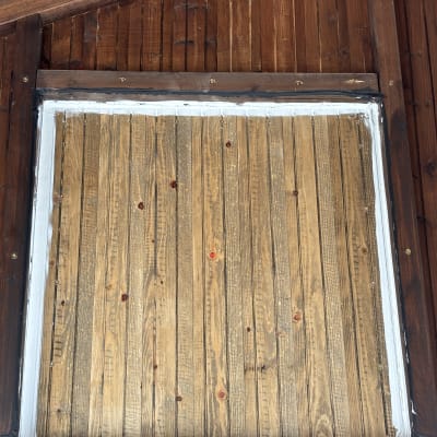 קיר עץ עם מסגרת כהה ולוחות עץ בהירים