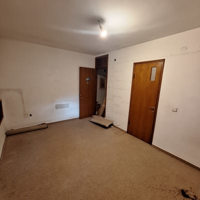 חדר ריק עם קירות לבנים ודלתות עץ, מתאים לצביעה