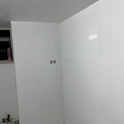 חדר אמבטיה עם אריחים לבנים ומוצרי טיפוח