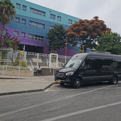 מיניבוס מרסדס שחור ויוקרתי להסעות חונה לצד המדרכה