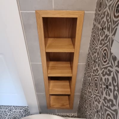 מדף עץ מובנה בקיר עם אריחים דקורטיביים