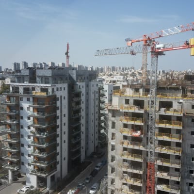 מנופים באתר בנייה עם בניינים גבוהים