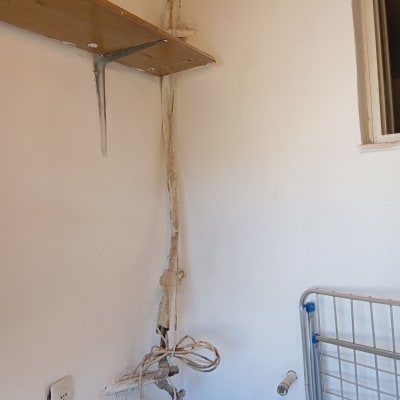 קיר עם מדף, חוטים וצינור, עבודה בתחום הצבע