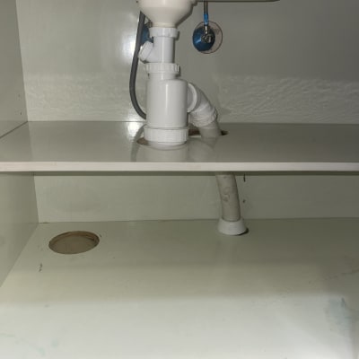 צנרת מתחת לכיור עם ברזים וחיבורים