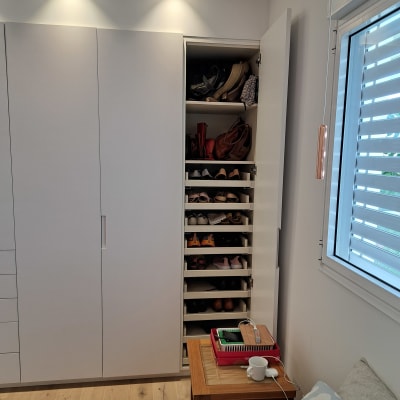 ארון נעליים פתוח עם מדפים מלאים בנעליים