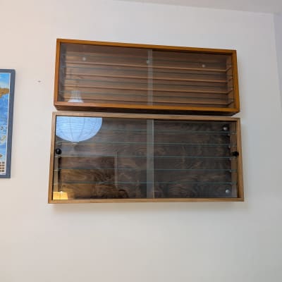 ארון עץ עם דלתות זכוכית על קיר לבן