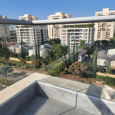 מעקה זכוכית במרפסת עם נוף עירוני