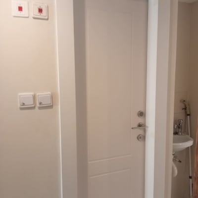 דלת לבנה עם ידית וכפתורים על הקיר