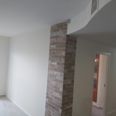 קיר גבס צבוע בלבן עם עמוד לבנים