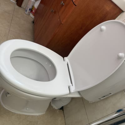 אסלה פתוחה בחדר אמבטיה עם ארון עץ