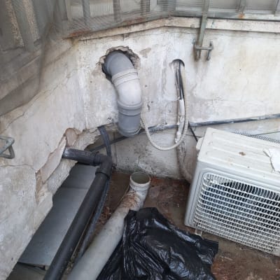 צינורות ביוב מחוברים לקיר עם חור