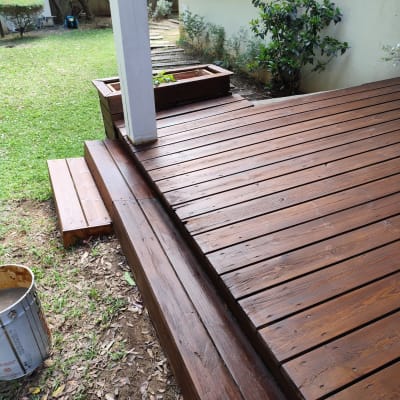 דק עץ בגינה עם עציץ עץ ועמוד לבן