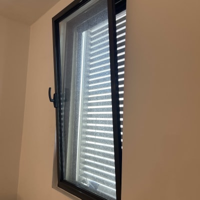 תריסים אופקיים מאחורי חלון פתוח למחצה