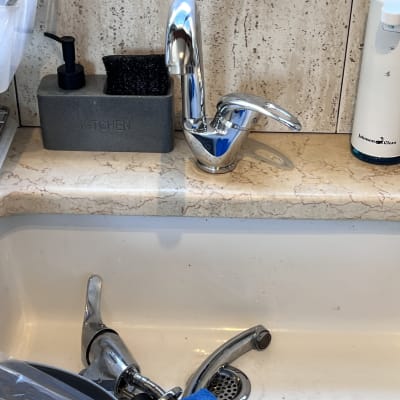 ברזים בכיור מטבח עם כלים לניקוי