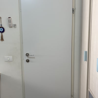 דלת לבנה עם ידית מתכת בחדר פנימי