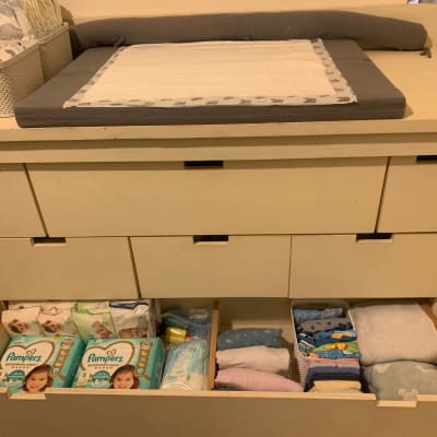 מגירות עם חיתולים ובגדי תינוקות מסודרים