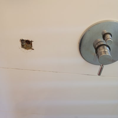 ברז מקלחת עם חור בקיר לידו