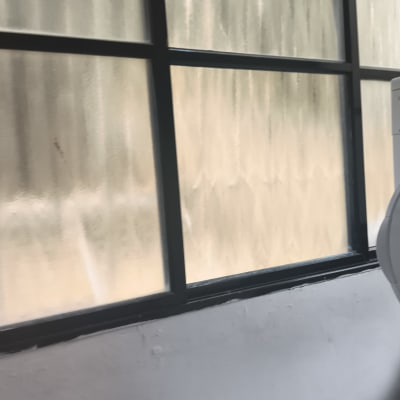 חלון זכוכית עם מסגרת מתכת בחדר פנימי