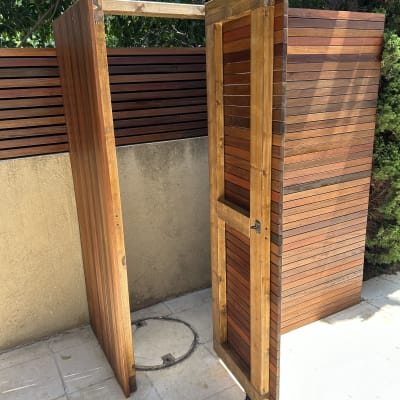 מבנה עץ עם דלת פתוחה על גלגלים בגינה