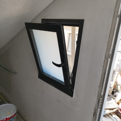 חלון עם תריס פתוח על קיר משופע