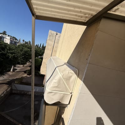 סוכך מרקיזה מתקפל בהיר המותקן על קיר חיצוני