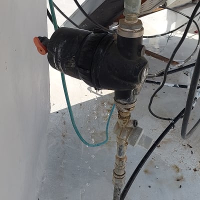 דליפת מים מצינור ליד שסתום שחור על גג