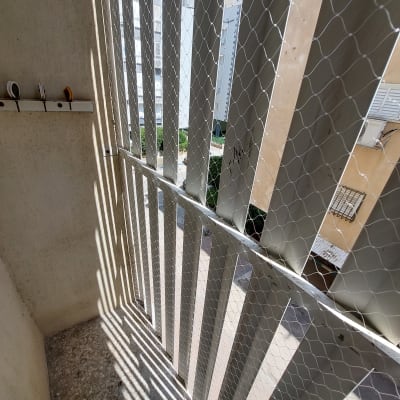 רשת מתכת מותקנת על מרפסת למניעת כניסת יונים