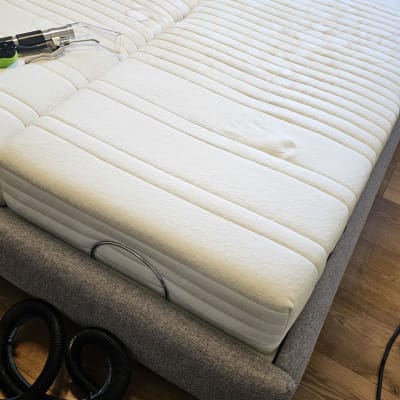 מזרן עם מכונת ניקוי על רצפת עץ